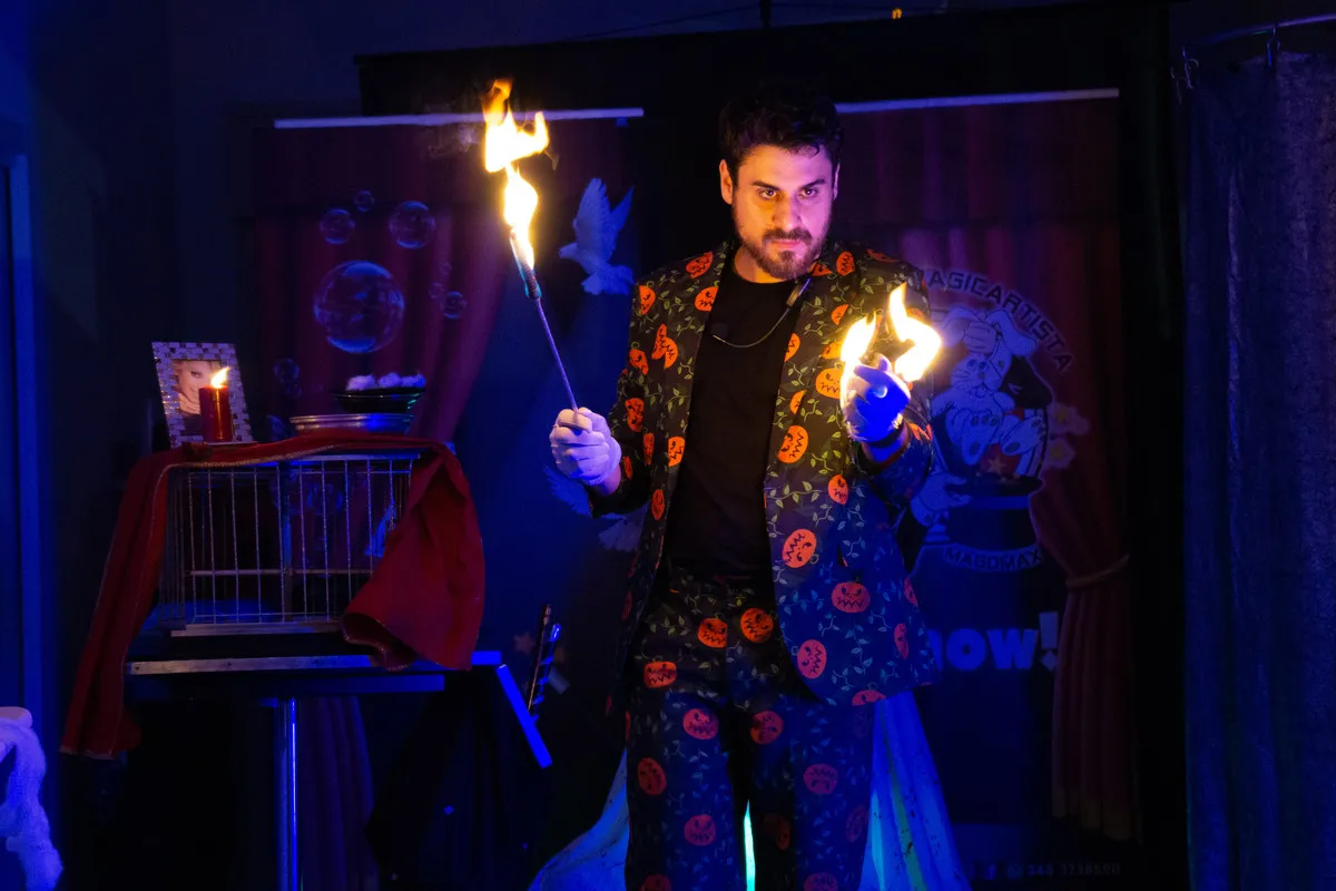 Il Mago Max con le fiamme accese tra le mani nel buio durante l'Halloween Show