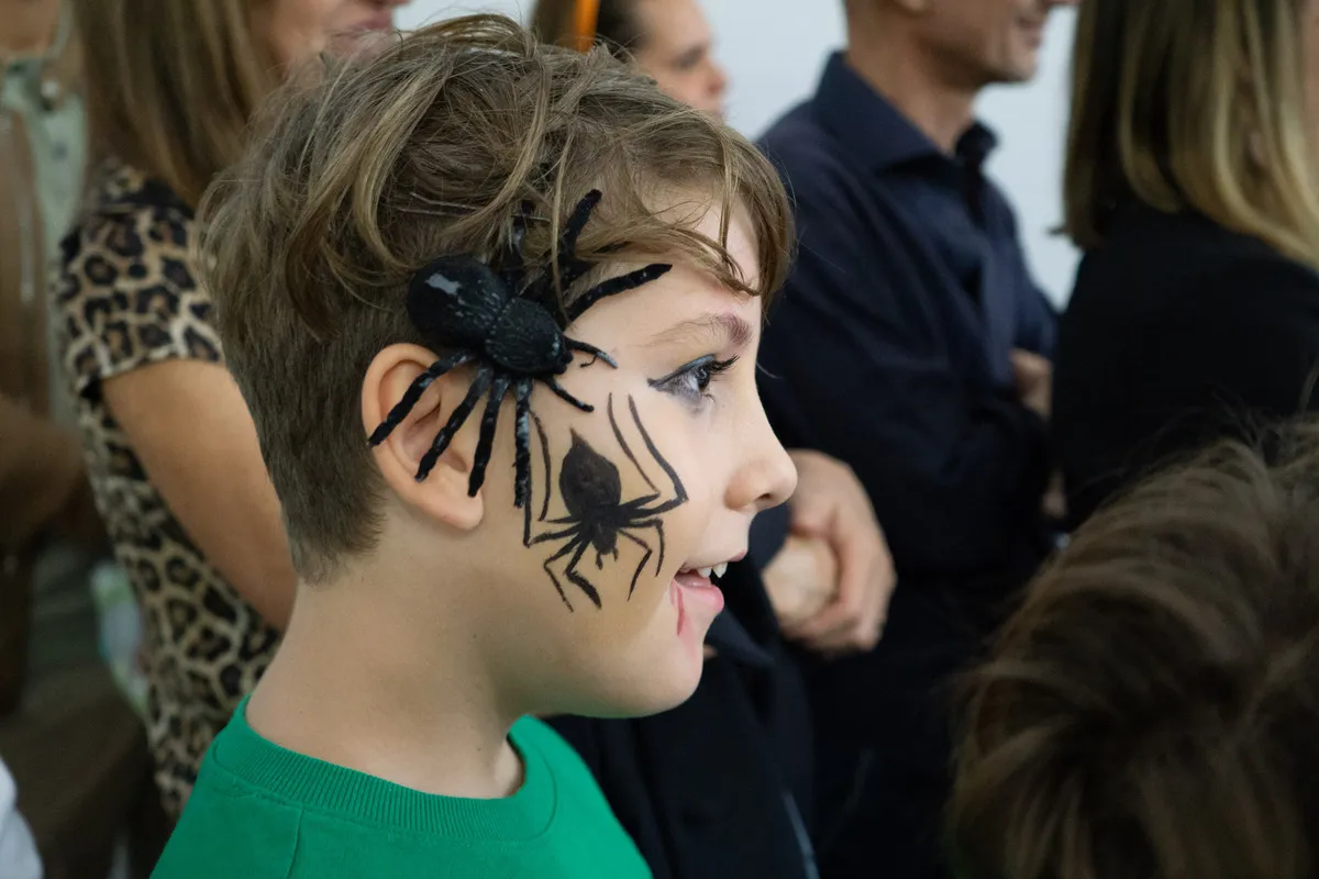 Bambino truccato da Halloween con un grande ragno sulla guancia