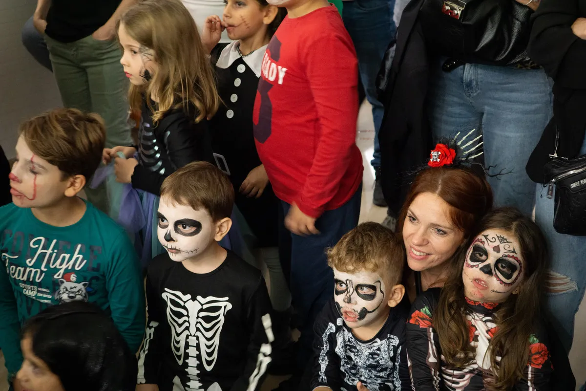 Bambini truccati da scheletro guardano lo spettacolo di magia