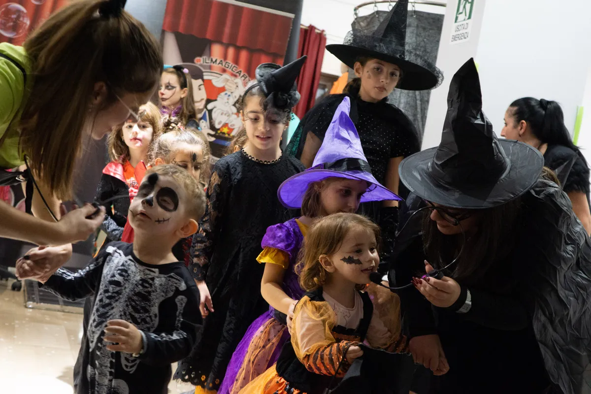 Bambini in maschera e genitori vestiti da strega durante la festa
